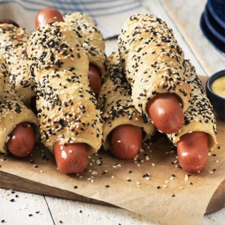 A tray of Halal Chicken Sausages wrapped in golden pastry with toasted black and white sesame seeds.