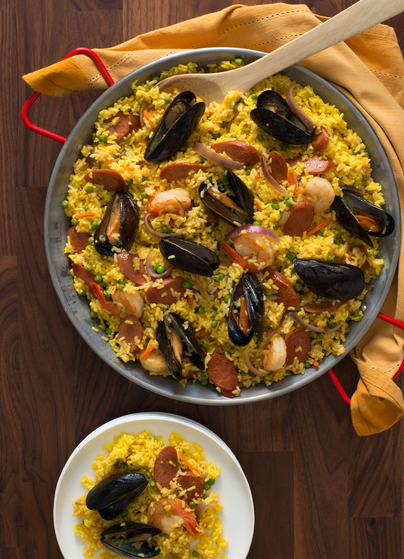 A bowl of Paella topped with mussels and sliced of Halal Chicken Franks