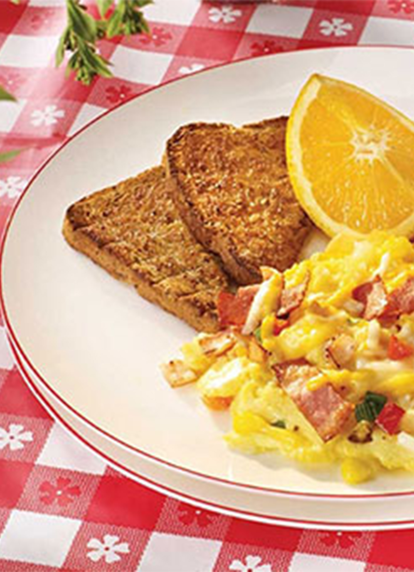 A breakfast platter with toast, fresh fruit, and scrambled eggs made with peppers and Breakfast Chicken Strips
